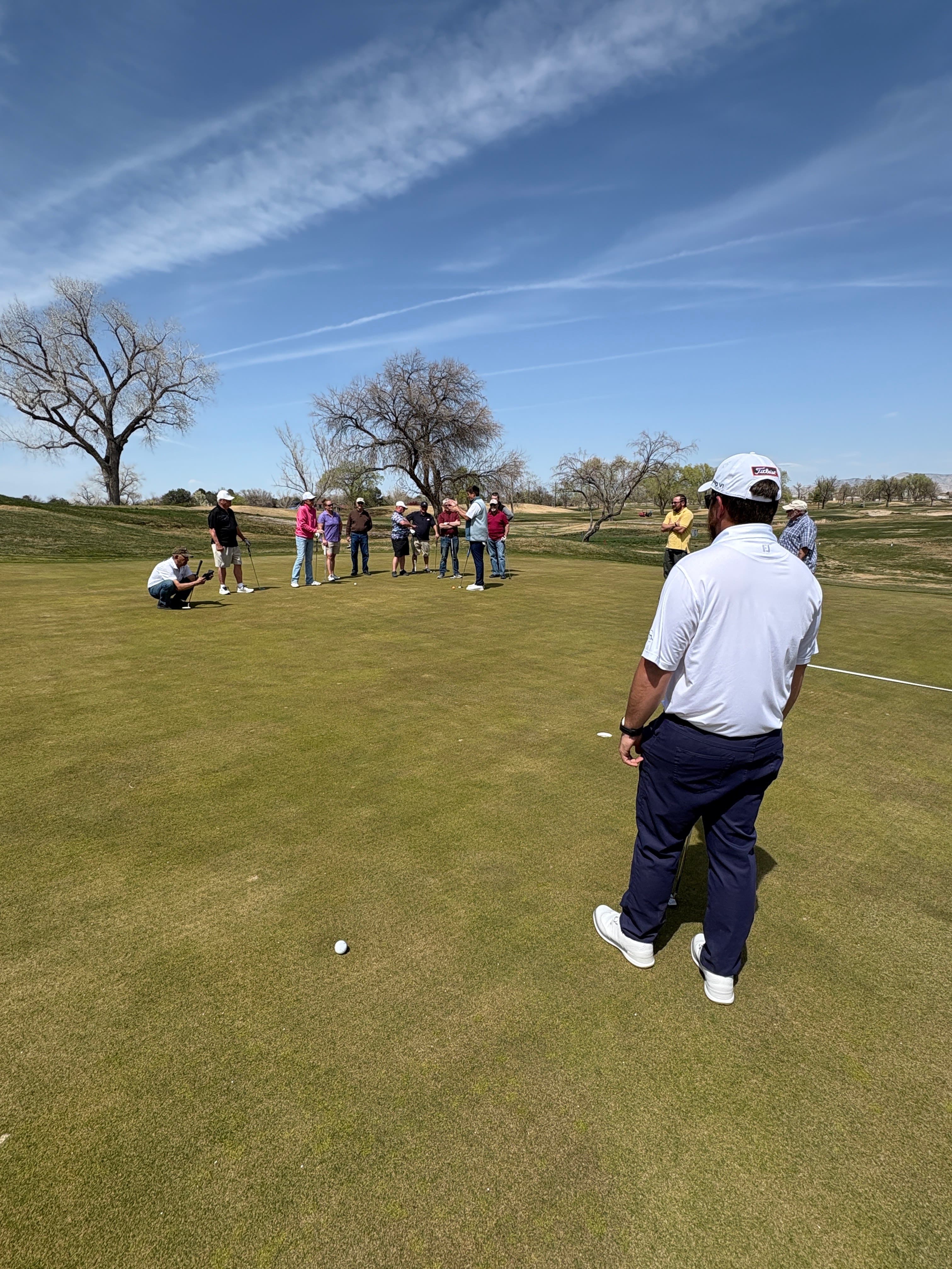 Alfonso Rivera Jr. leading a group putting lesson on the practice green